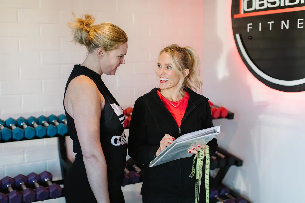 An Obsidian® trainer taking a client through measurements and goals at the studio