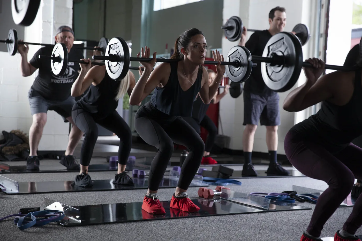An Obsidian® SCULPT class working through a barbell back squat